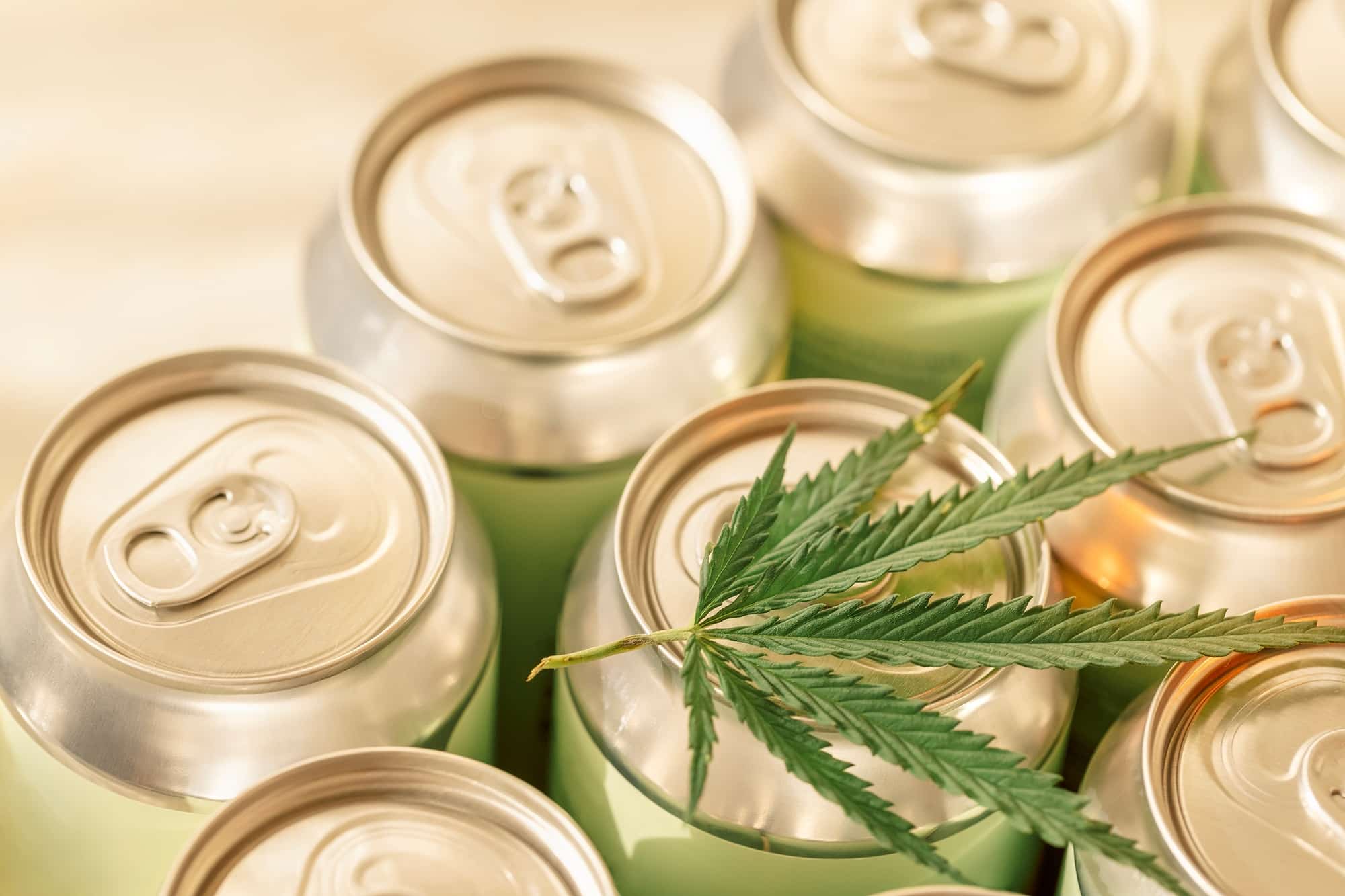 A collection of aluminum cans with a cannabis leaf. Trending concept of CBD-infused beverages